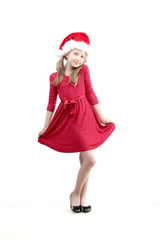 the vertical portrait of standing beautiful smiling little girl wearing on red dress and Santa Claus hat on white background