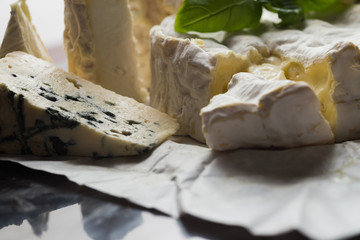Cheese assorted on a table background. Variety sorts for appetizing, gourmet, delicious snacks. Traditional French dish for wine on lunch and dinner closeup. Camembert, Roquefort.
