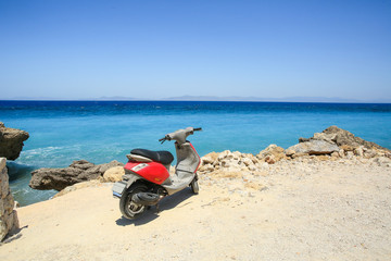 Rhodes sea coast with red scooter parking 