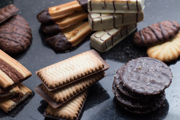 Cookies assorted on black background. Delicious morning snacks for breakfast, brunch and lunch. Appetizing, sweet and fast food.
