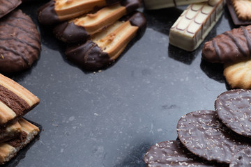 Cookies assorted on black background. Delicious morning snacks for breakfast, brunch and lunch. Appetizing, sweet and fast food.
