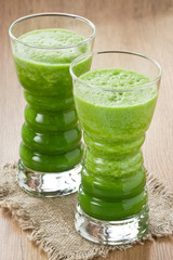 Green spinach smoothie / Fresh spinach and green apple smoothie in two glass on wooden background