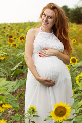 Fototapeta na wymiar Pregnant girl in sunflowers field