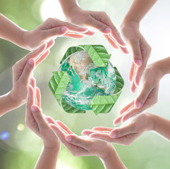 Collaborative human hands protecting green planet with recycle arrow sign leaf on blur abstract...