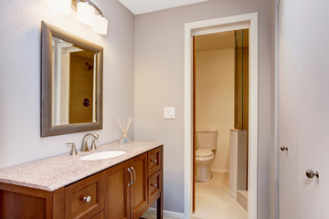 Modern bathroom with vanity cabinet, granite counter top and mirror.