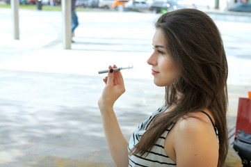 Woman smokes electronic cigarette.