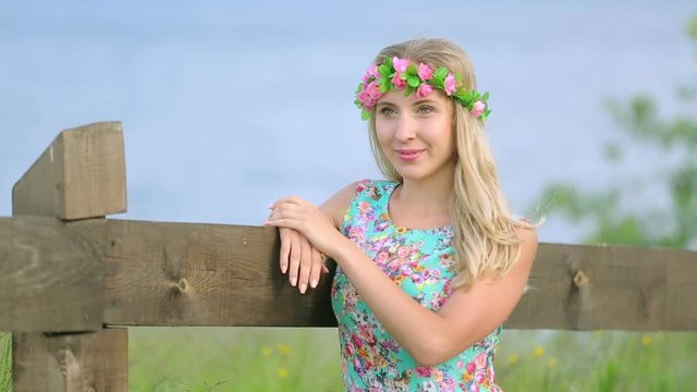 Portrait of attractive girl with flower wreath on her head. Beautiful woman with flower wreath.