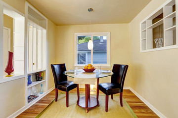 Beige dining room with hardwood floor and rug.