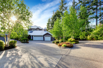 Modern house exterior with curb appeal. View of garage and spacious driveway