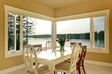 Dining room interior with white table set and tile floor.