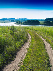Fototapeta na wymiar Vertical classic Russian road to river landscape background