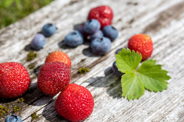 Fresh blueberries and strawberries on rustic table. Healthy diet.