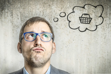 Junger Mann denkt an Warenkorb