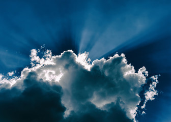 Naklejka premium Horizontal blue dramatic cloudscape with rays of light abstracti