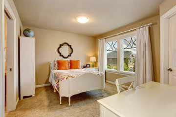 American antique bedroom interior with white desk and orange pillows on the bed.