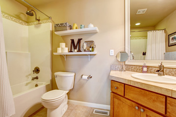 Cozy antique bathroom interior in white tones with shelves on the wall.