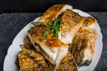 Fried fish with golden crust on a white plate
