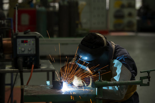 man welding steel by skill.Men wear protective clothing during work.