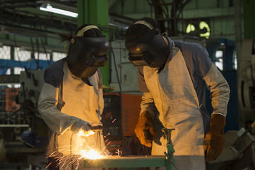 workers with protective mask welding metal