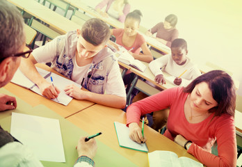 Enthusiastic girls and boys taking the notes while