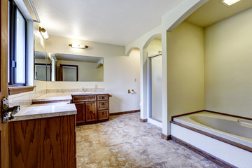 Luxury bathroom interior with wooden cabinets and white bath tub
