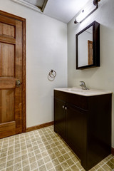 Fototapeta na wymiar Simple bathroom interior with black cabinets and white sink
