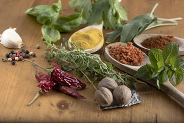 Various colorful spices and food drugs on wooden table, some are dried and ground, others are fresh