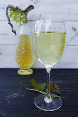 White wine in glass and antique wine pitcher