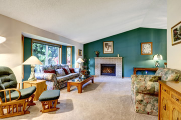 Elegant white and green living room. Classic American design: brick fireplace, rocking chair and colorful sofa
