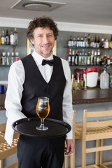 Waiter holding a tray with beer glass