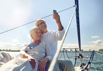 senior couple taking selfie by smartphone on yacht