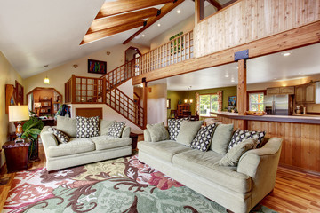 Light living room with hardwood floor and high ceiling with wooden beams.