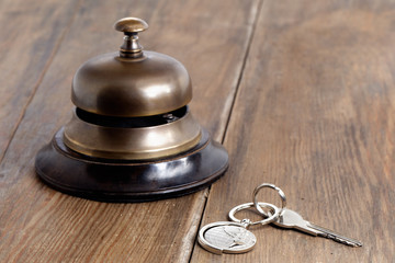 Reception bell and hotel key on a reception desk