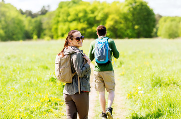 happy couple with backpacks hiking outdoors