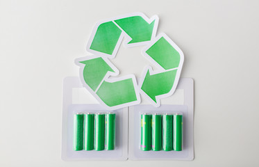 close up of batteries and green recycling symbol