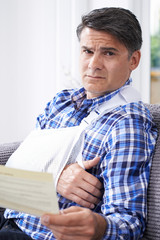 Mature Man Reading Letter About Injury