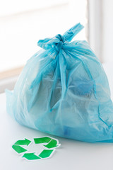 close up of rubbish bag with green recycle symbol