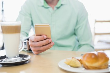 Mid-section of man using mobile phone 