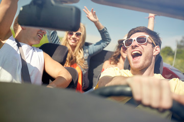 happy friends driving in cabriolet car