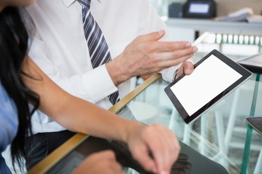 Businessman discussing with colleague over digital tablet