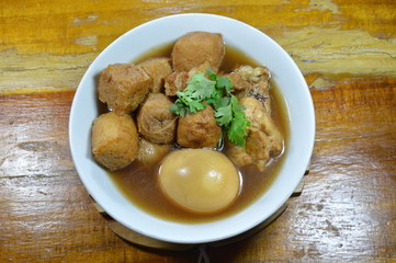 boiled egg with tofu and chicken in Chinese herb brown soup on bowl