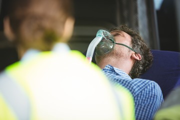 Close-up of an injured man wearing oxygen mask