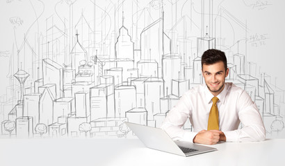 Businessman sitting at the white table with hand drawn buildings