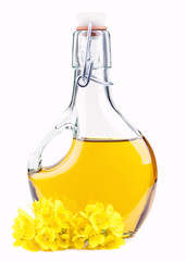 Extra virgin  oil in a bottle with rapeseed flowers