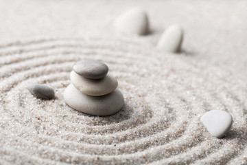 Fototapeta na wymiar Japanese zen garden meditation stone for concentration and relaxation sand and rock for harmony and balance in pure simplicity - macro lens shot