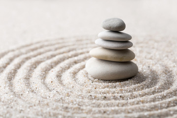 Fototapeta na wymiar Japanese zen garden meditation stone for concentration and relaxation sand and rock for harmony and balance in pure simplicity - macro lens shot