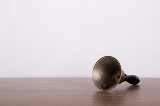 Old fashioned hand bell a wooden surface