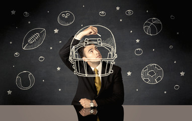 Businessman drawing helmet and sport balls