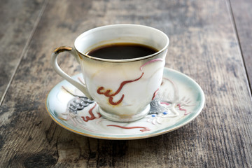 Coffee cup vintage style and beans coffee on a rustic wooden table

