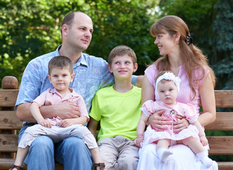 happy family portrait on outdoor, group of five people sit on wooden bench in city park, summer season, child and parent